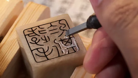 Focused tool and artisan craftsman hands using a gouge to carve intricate Stock Footage 337908854