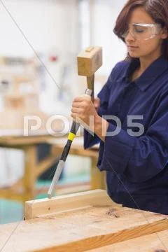 Focused trainee using mallet and chisel Stock Photos
