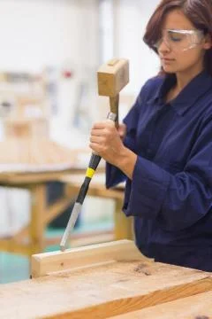 Focused trainee using mallet and chisel Stock Photos