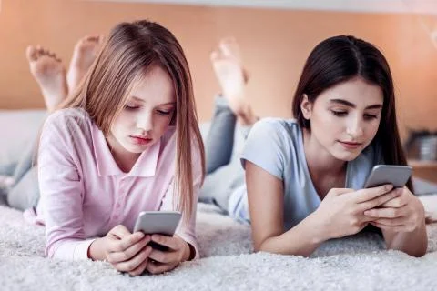 Focused two girls scrolling web pages down Stock Photos