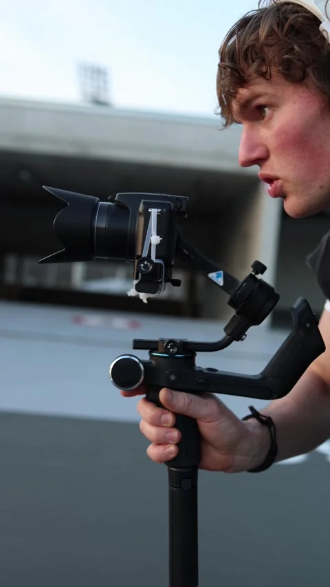 Focused videographer adjusting camera on stabilizer Stock Footage 332116772