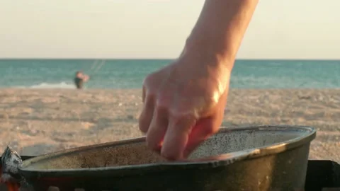 Focused view of cook's hands mixing meals in a pot on fire. Defocused view of Stock Footage 139964746