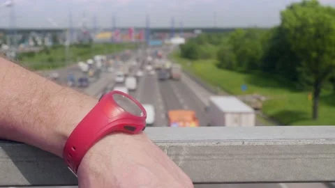 Focused view of man's hand with red wristwatch on rail of bridge over Moscow Stock Footage 133790975