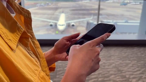 Focused view of traveler using a smartphone by the window Stock Footage 308878696