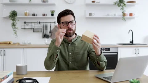 Focused vlogger sitting at desk and holding cardboard parcel Stock Footage 253364580