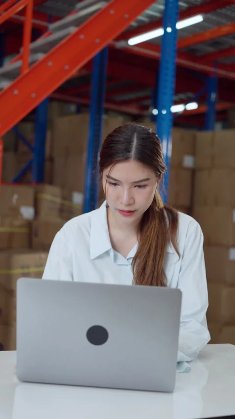 Focused warehouse manager working on laptop. Stock Footage 279397706