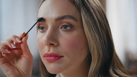 Focused woman brushing brows making good shape closeup. Model girl doing makeup Stock Footage 281796938