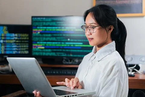 Focused Woman Coding on Laptop 库存照片