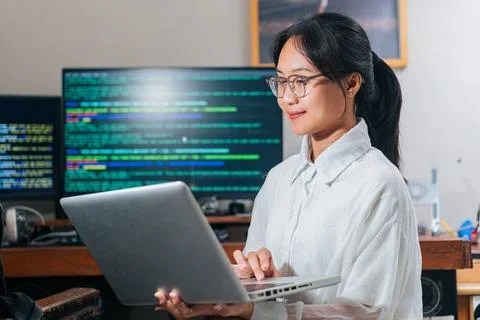 Focused Woman Coding on Laptop 스톡 사진