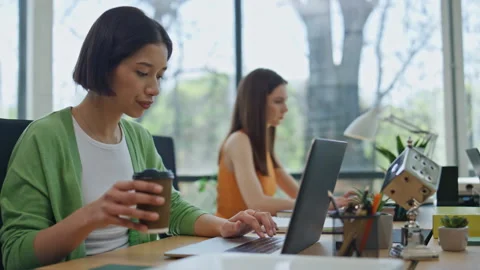 Focused woman drinking coffee typing laptop cabinet closeup. Startupers working Stock Footage 251835211