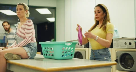 Focused woman sorting through her underwear from her laundry basket in interior Stock Footage 199460211
