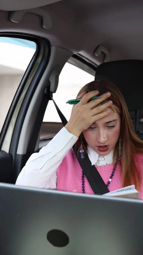 Focused woman takes notes while working on laptop during a productive car ride Stock-Footage 346705096