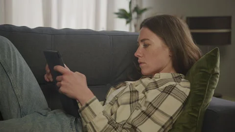 Focused Woman Using Digital Tablet on Living Room in Apartment Stock Footage 285506854