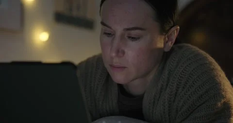 Focused Woman Using a Digital Tablet in Bed at Night Stock Footage 328728217