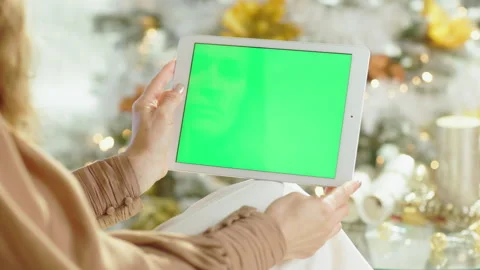 Focused Woman Using Tablet in Festive Setting Stock Footage 318107465