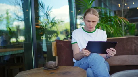 Focused Woman Using Tablet in Modern Cafe 库存影片 335455380