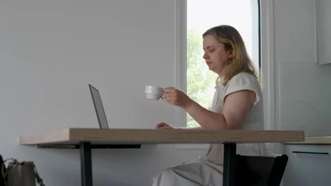Focused Woman Working on Laptop While Enjoying Coffee Stock Footage 317018494