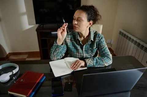 Focused Woman Writing Notes While Working on a Desk in a Home Office Stock Photos