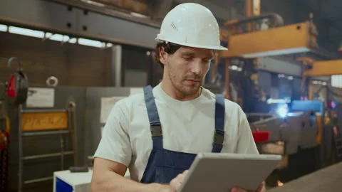 Focused Worker in Hard Hat Using Digital Tablet in Industrial Factory 動画素材 296263279