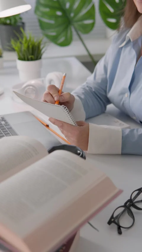 A Focused Workspace Engaging in Writing Surrounded by an Abundance of Books and Stock Footage 281151983