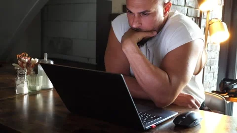 Focused Young Athletic Man Working on Laptop Computer at Cozy Cafe Stock Footage 347200179