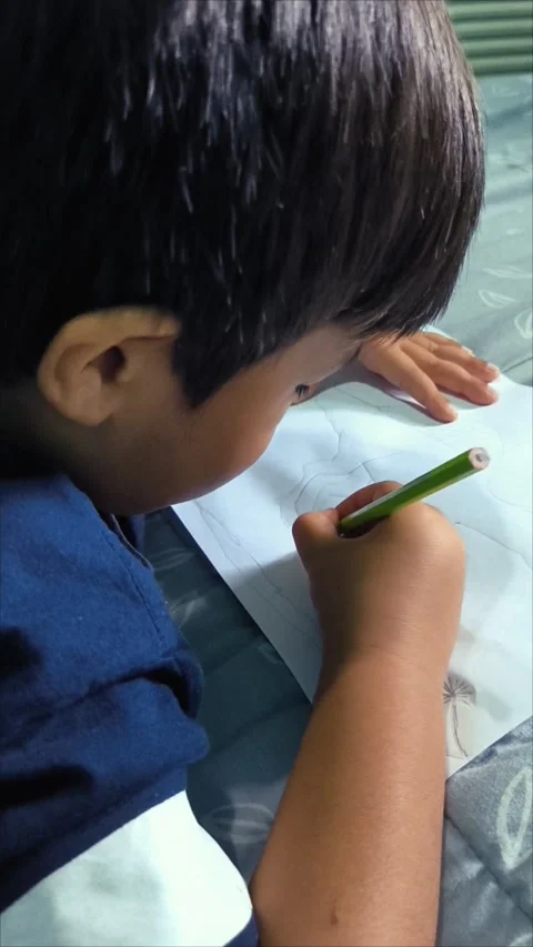 Focused Young Boy Drawing on Paper Stock Footage 312104535