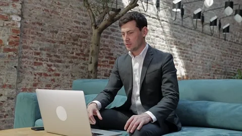 Focused young businessman making video calls with clients on laptop. Concentr Stock Footage 169766228