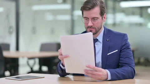 Focused Young Businessman Reading Documents Stock Footage 139698940