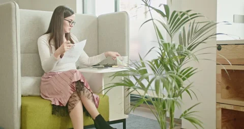 A focused young employee reviews complex data analysis and graph charts in a Stock Footage 276924403