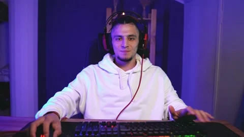 Focused young gamer guy sitting on armchair Видео 144369801