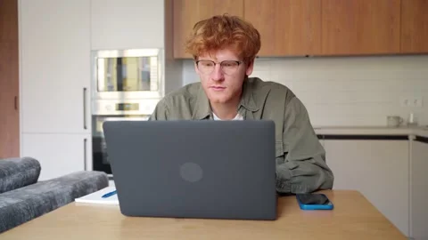 Focused young ginger irish man watching webinar video course writing notes Stock Footage 196615669