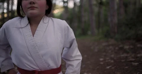 A Focused Young Girl in a Karate Gi and Red Belt Practices Meditation and Stock Footage 339499863