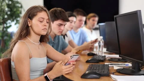 Focused young girl undergoing training in mobile applications development Stock Footage 303742442