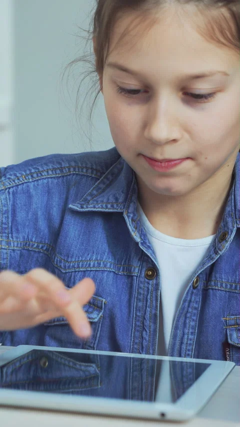 Focused young girl using smart digital tablet on desk at home Video stock 347513852