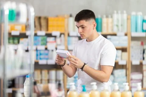 Focused young guy choosing pill box and making decisions about pharmaceuticals Stock Photos
