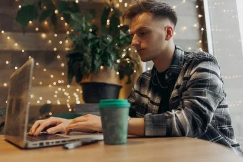 Focused young guy freelancer typing on laptop in cafe 스톡 사진