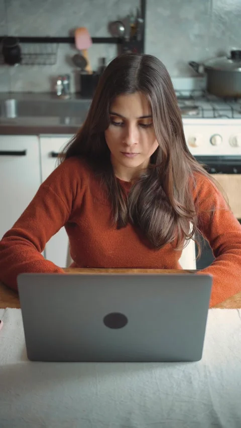 Focused young Hispanic woman using her laptop at home, highlighting concentratio Stock Footage 346321955