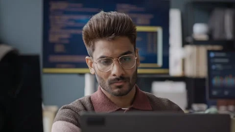 Focused Young Indian Male Software Developer Working on Computer in Tech Office Stock Footage 337474036
