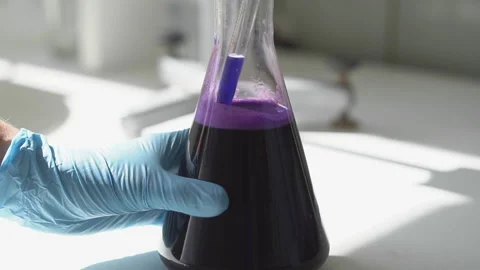 Focused young life science professional pipetting solution into the glass Stock Footage 95549922