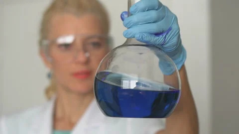 Focused young life science professional pipetting solution into the glass Stock Footage 95550022