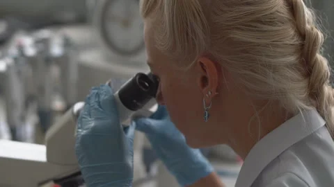 Focused young life science professional pipetting solution into the glass Stock Footage 95551231
