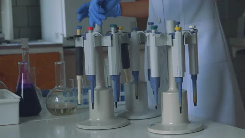 Focused young life science professional pipetting solution into the glass Stock Footage 95596781
