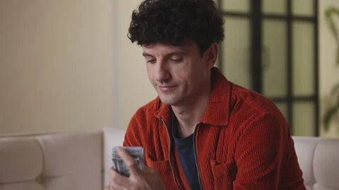 Focused young male counting dollars at home, feeling happy about business profit Stock Footage 341017374