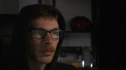 Focused young male programmer in eyeglasses is using laptop computer in dark Stock Footage 138081885