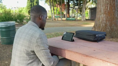 Focused Young Man Chats on Tablet in Open Air Remote Work Environment. Stock Footage 308688704