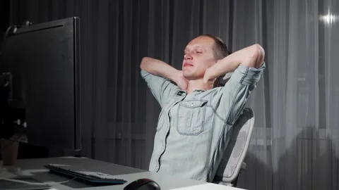 Focused young man completing work on his computer late at night Stock Footage 311180976