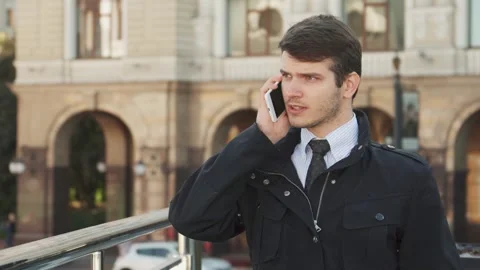 Focused young man engaged in a serious phone conversation Stock Footage 311985100