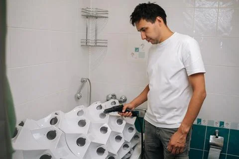 Focused young man sanitizing vertical hydroponic tower garden with steam cleaner Stock Photos