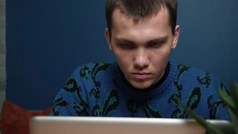 A focused young man working and using his laptop at home or office. Stock Footage 144629807