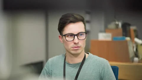Focused young man working on computer in modern office setting Stock Footage 317539700